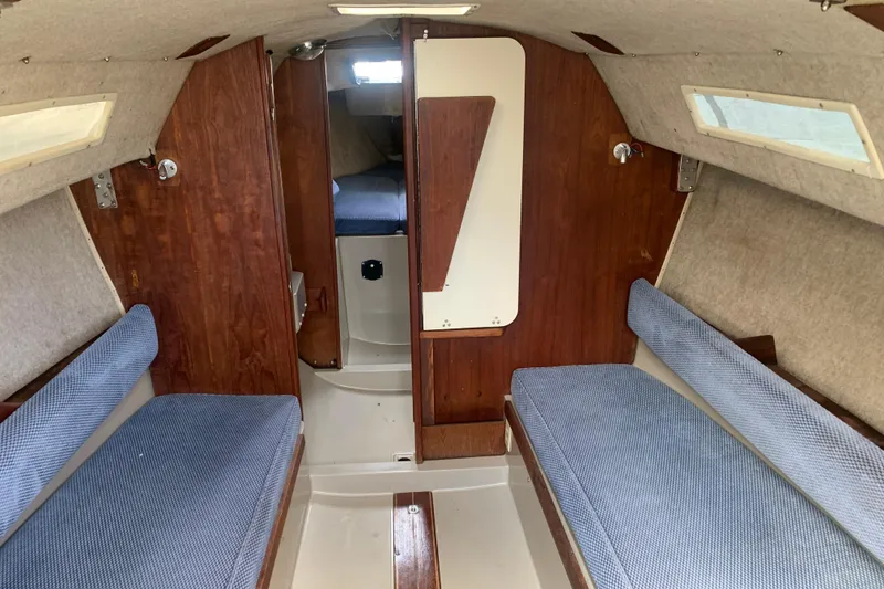 Slide: The Image of Interior of a 1985 Oday 272 sailboat, featuring cozy seating and wooden paneling. - 16