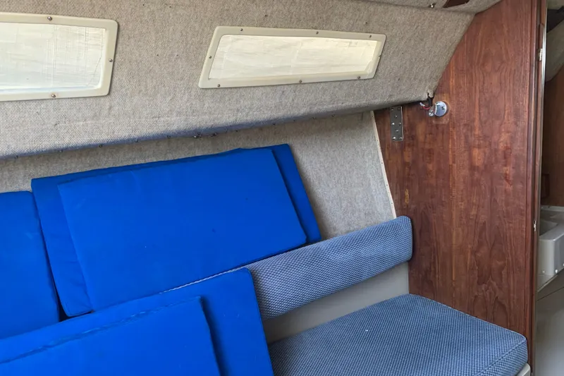 Slide: The Image of Interior of 1985 Oday 272 sailboat with blue cushions and wooden paneling. - 18