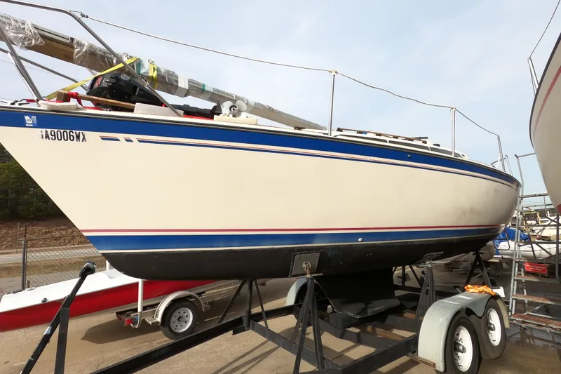 Slide: The Image of 1985 Oday 272 sailboat on trailer, white hull with blue and red stripes. - 2