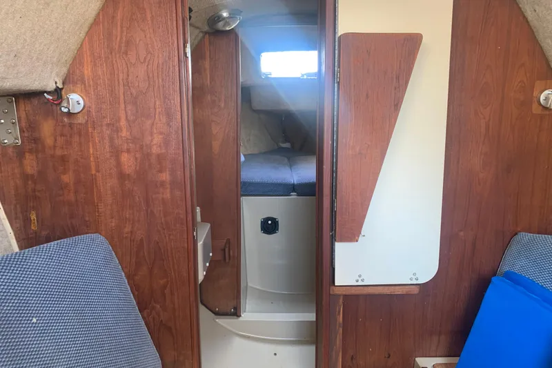 Slide: The Image of Interior of a 1985 Oday 272 sailboat, featuring wood paneling and cozy cabin space. - 21