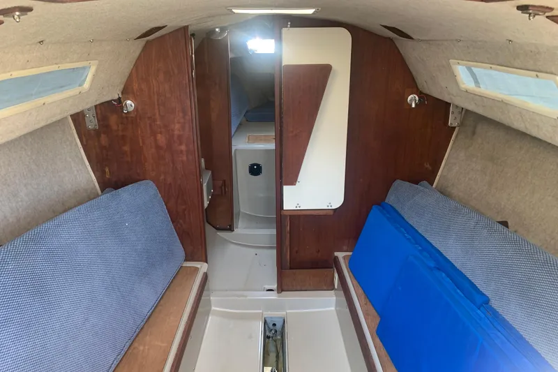 Slide: The Image of Interior of a 1985 Oday 272 sailboat with wooden paneling and blue cushions. - 23