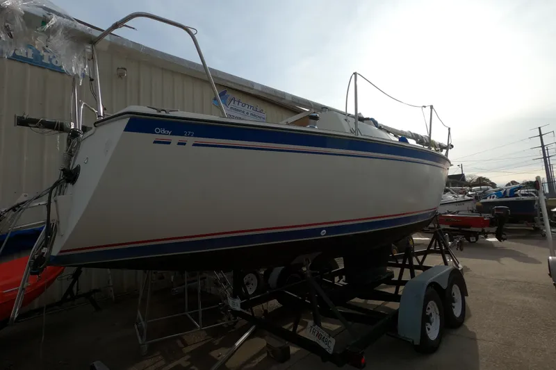 Slide: The Image of 1985 Oday 272 sailboat on trailer, displayed outdoors near a marine shop. - 5