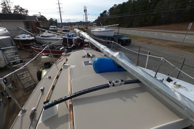 Slide: The Image of 1985 Oday 272 sailboat on trailer, surrounded by other boats, near a road. - 8