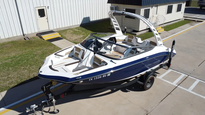 Slide: The Image of 2022 Yamaha TP1800C-XAP boat on trailer in front of building. - 11