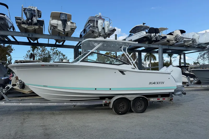 Slide: The Image of 2022 Blackfin 272 DC boat on trailer, surrounded by other boats in storage. - 1