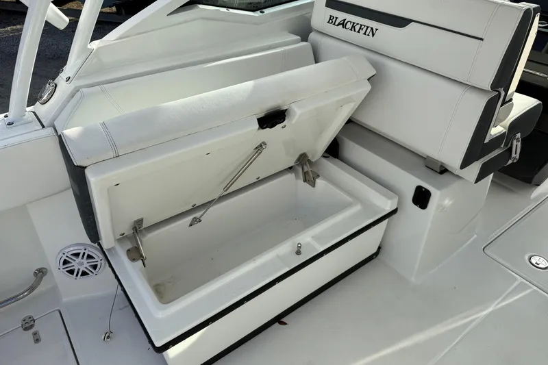 Slide: The Image of 2022 Blackfin 272 DC boat interior with open storage compartment and seating. - 11
