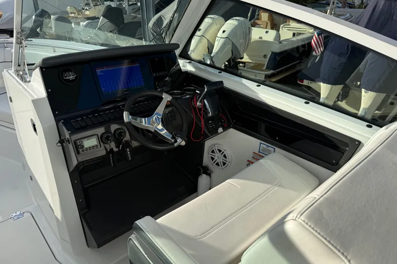 Slide: The Image of Interior view of 2022 Blackfin 272 DC boat cockpit with steering wheel and control panel. - 14
