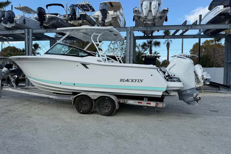 The Image of 2022 Blackfin 272 DC boat on trailer, parked in marina storage area. - 2