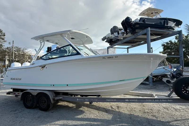 Slide: The Image of 2022 Blackfin 272 DC boat on trailer, parked outdoors under cloudy sky. - 5