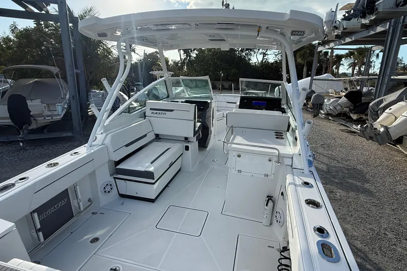 Slide: The Image of 2022 Blackfin 272 DC boat interior with seating and storage, docked outdoors. - 6