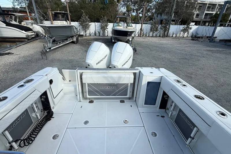 Slide: The Image of 2022 Blackfin 272 DC boat with dual Mercury engines in a marina setting. - 7