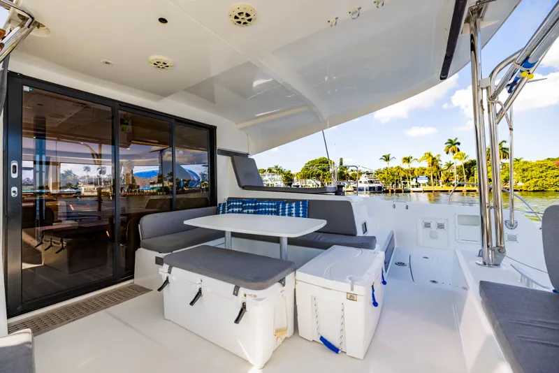 Slide: The Image of 2018 Lagoon 42 catamaran with cozy outdoor seating and palm tree view. - 45