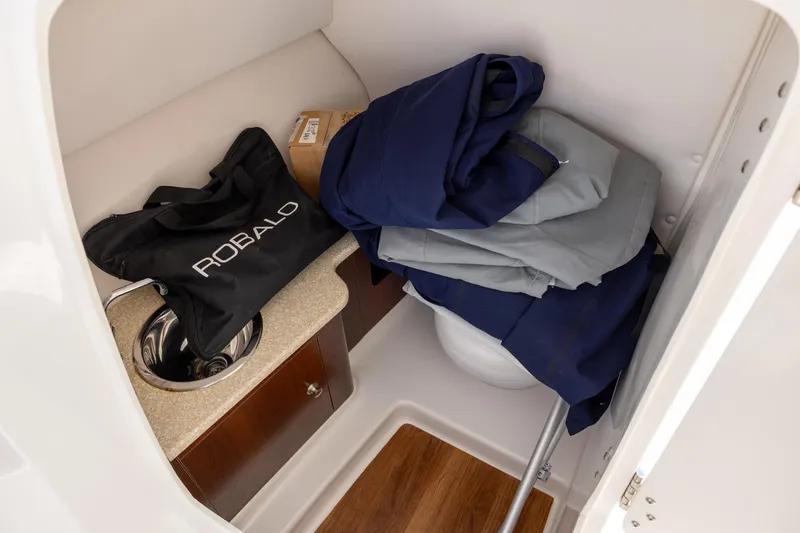 Slide: The Image of 2018 Robalo R247 Dual Console interior storage with sink and gear. - 13