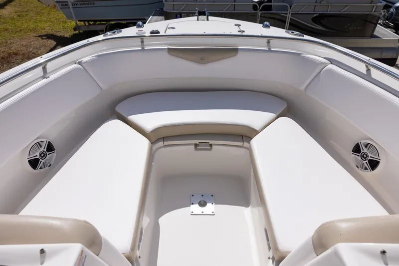 Slide: The Image of 2018 Robalo R247 Dual Console boat interior with cushioned seating and speakers. - 14