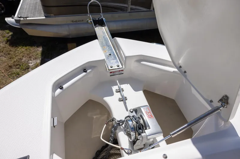Slide: The Image of 2018 Robalo R247 Dual Console boat anchor compartment with open hatch and winch system. - 15