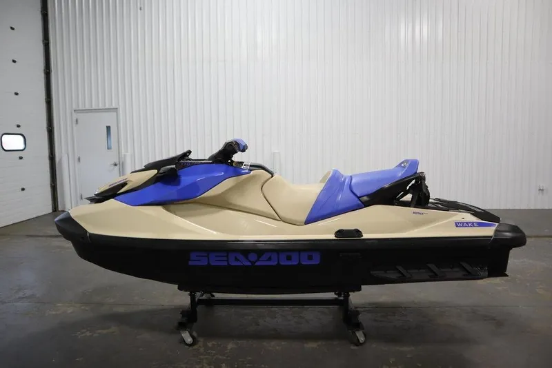 Slide: The Image of 2025 Sea-Doo Wake 170 jet ski in a showroom, featuring a blue and beige design. - 10