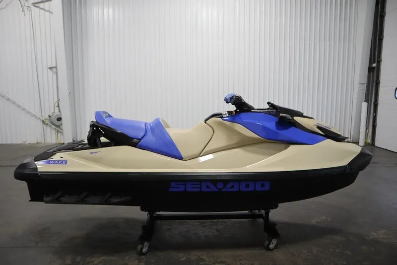 Slide: The Image of 2025 Sea-Doo Wake 170 jet ski in beige and blue, displayed indoors. - 5