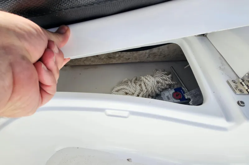 Slide: The Image of Hand opening storage compartment on 2020 Walker Bay Generation 360 boat. - 16