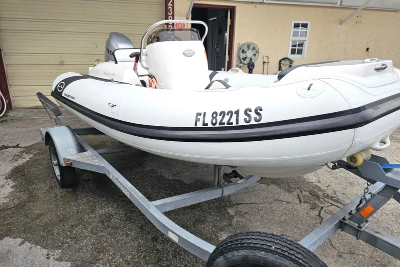 Slide: The Image of 2020 Walker Bay Generation 360 boat on trailer, parked outside a garage. - 20