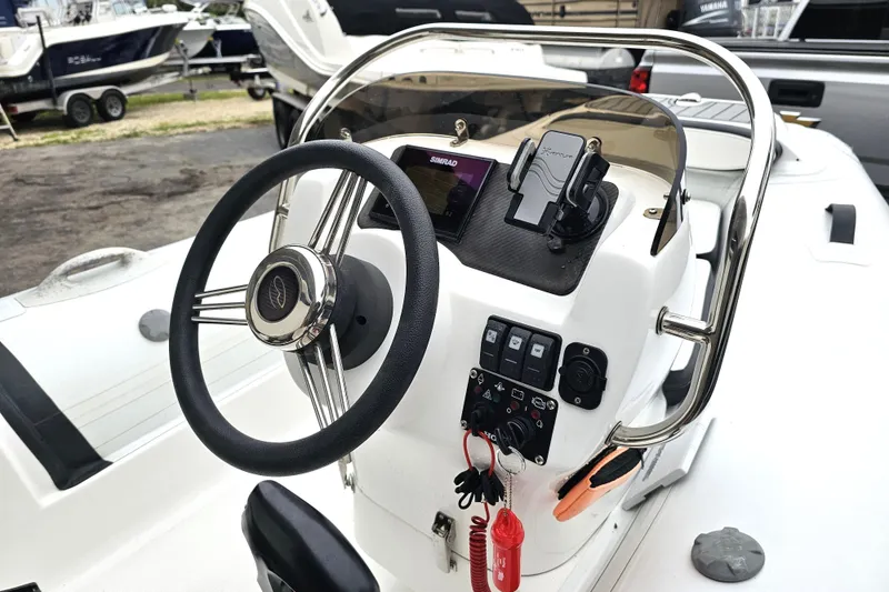 Slide: The Image of 2020 Walker Bay Generation 360 boat dashboard with steering wheel and control panel. - 33