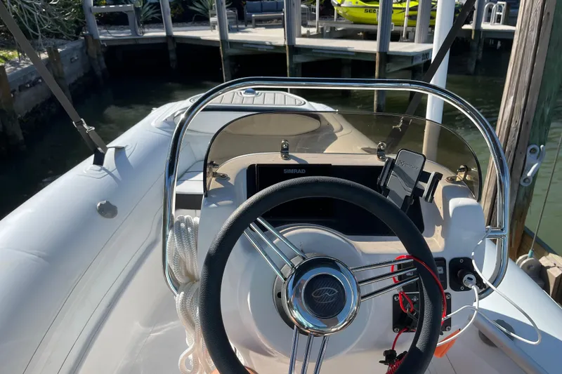Slide: The Image of 2020 Walker Bay Generation 360 boat steering console with modern controls and dock view. - 4