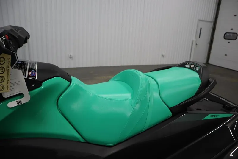 Slide: The Image of 2026 Sea-Doo GTI SE 170 jet ski with vibrant green seat in a showroom. - 16