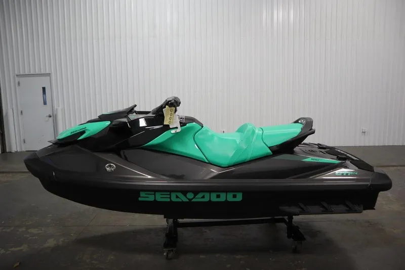 Slide: The Image of 2026 Sea-Doo GTI SE 170 jet ski in a showroom, featuring a sleek black and teal design. - 7