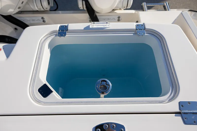 Slide: The Image of Livewell on 2022 Cobia 320 Center Console boat, featuring a clear lid and secure latch. - 10