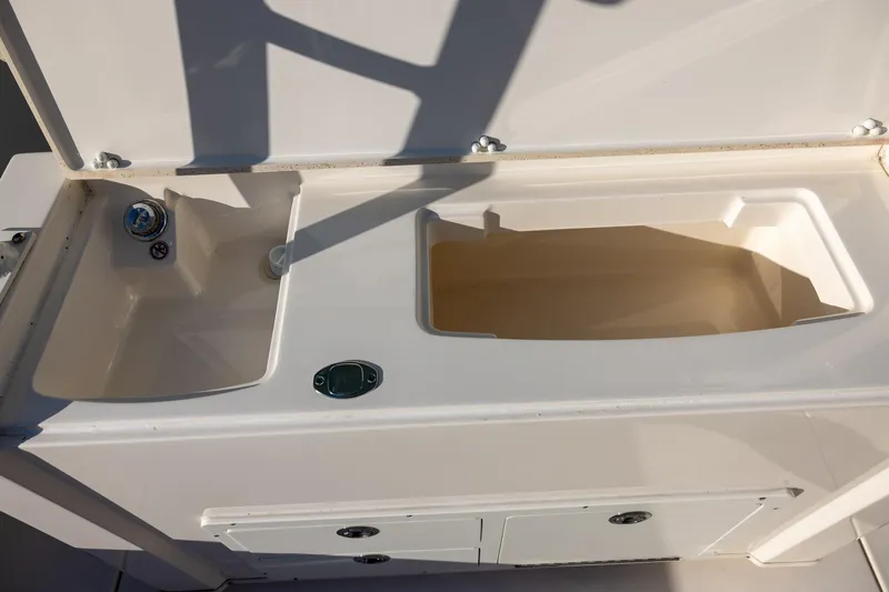Slide: The Image of 2022 Cobia 320 Center Console boat sink and storage compartment. - 11