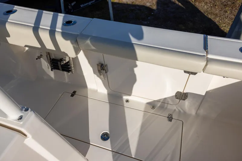 Slide: The Image of 2022 Cobia 320 Center Console boat interior with storage compartments and cushioned seating. - 12