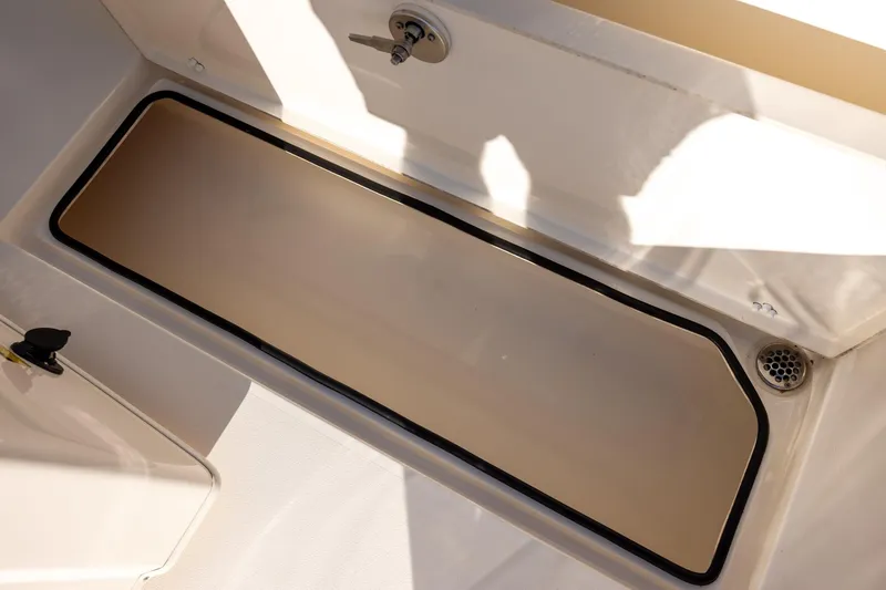 Slide: The Image of 2022 Cobia 320 Center Console storage compartment with drain, featuring a sleek design. - 14