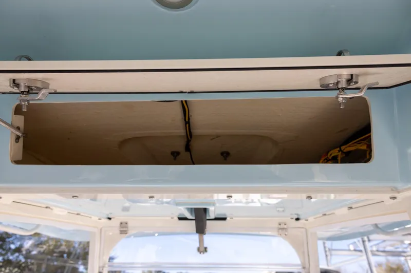 Slide: The Image of 2022 Cobia 320 Center Console storage compartment with open hatch and visible wiring. - 18