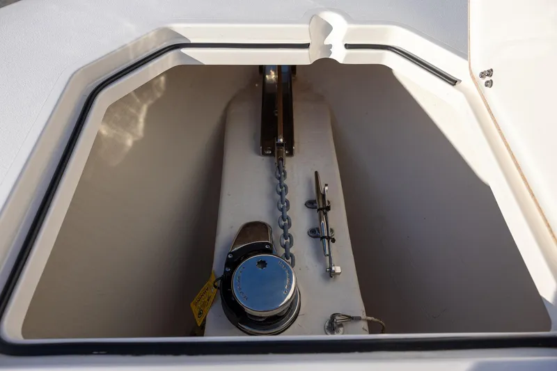 Slide: The Image of Anchor compartment of 2022 Cobia 320 Center Console boat with chain and winch. - 21