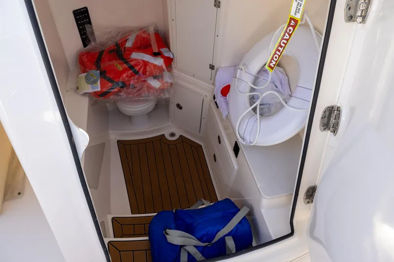 Slide: The Image of Interior of 2022 Cobia 320 Center Console with life jackets and safety equipment. - 23