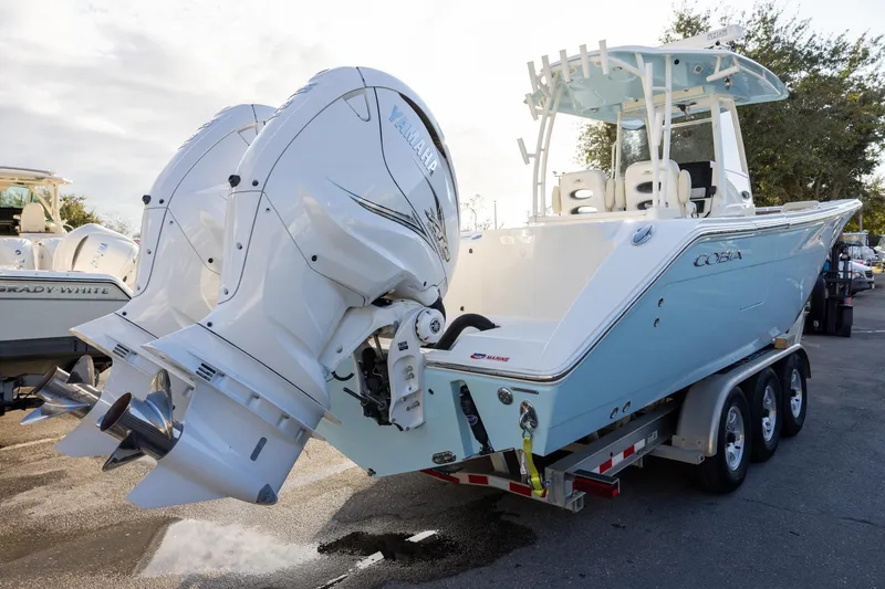 Slide: The Image of 2022 Cobia 320 Center Console boat with dual Yamaha engines on a trailer. - 4