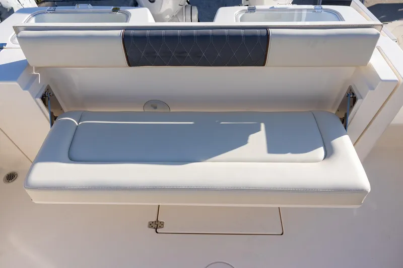 Slide: The Image of 2022 Cobia 320 Center Console boat with cushioned seating and storage compartment. - 8