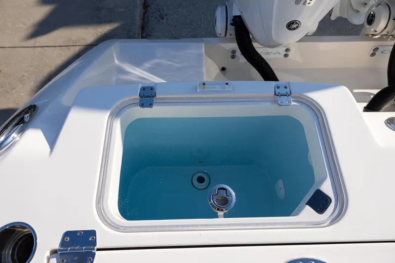 Slide: The Image of 2022 Cobia 320 Center Console livewell with clear lid and blue interior. - 9