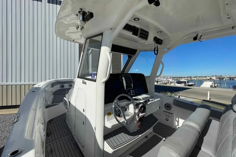 Slide: The Image of 2013 Everglades 355 Center Console boat interior with steering wheel and seating. - 6