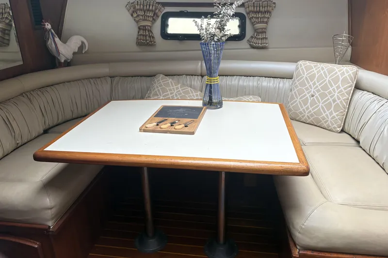 Slide: The Image of 1987 Californian 53 Cockpit Motor Yacht interior with dining area, cushioned seating, and decorative elements. - 5