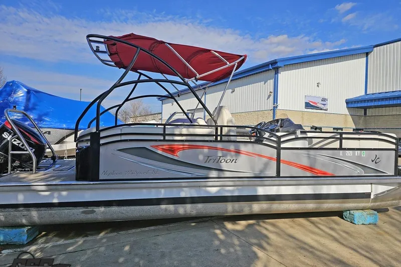 Slide: The Image of 2019 JC Tritoon Neptoon 25 Sport SL pontoon boat with red canopy, docked outdoors. - 12