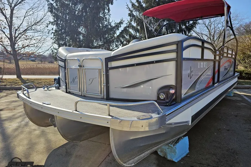Slide: The Image of 2019 JC Tritoon Neptoon 25 Sport SL pontoon boat with red canopy, parked outdoors. - 22