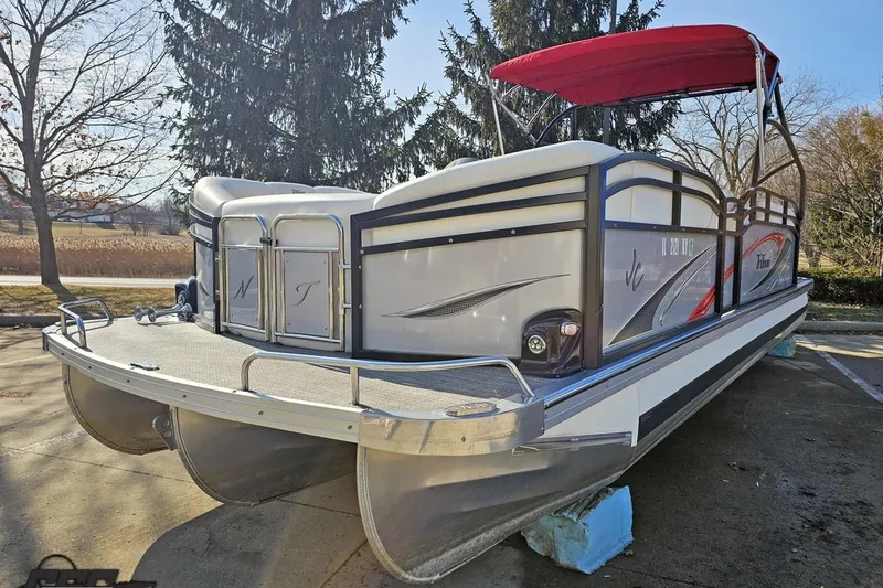 Slide: The Image of 2019 JC Tritoon Neptoon 25 Sport SL pontoon boat with red canopy, parked outdoors. - 23