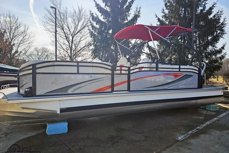 Slide: The Image of 2019 JC Tritoon Neptoon 25 Sport SL pontoon boat with red canopy, parked outdoors. - 26