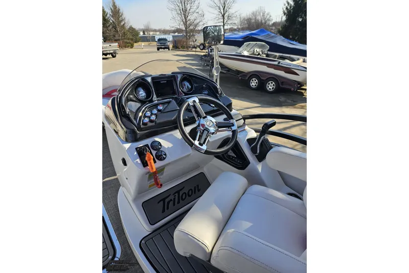 Slide: The Image of 2019 JC Tritoon Neptoon 25 Sport SL boat dashboard with steering wheel and controls. - 54