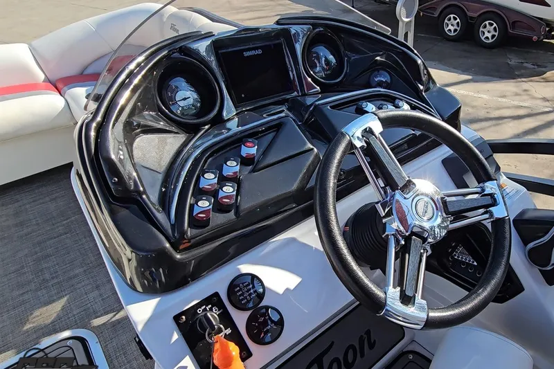 Slide: The Image of 2019 JC Tritoon Neptoon 25 Sport SL dashboard with steering wheel and controls. - 56
