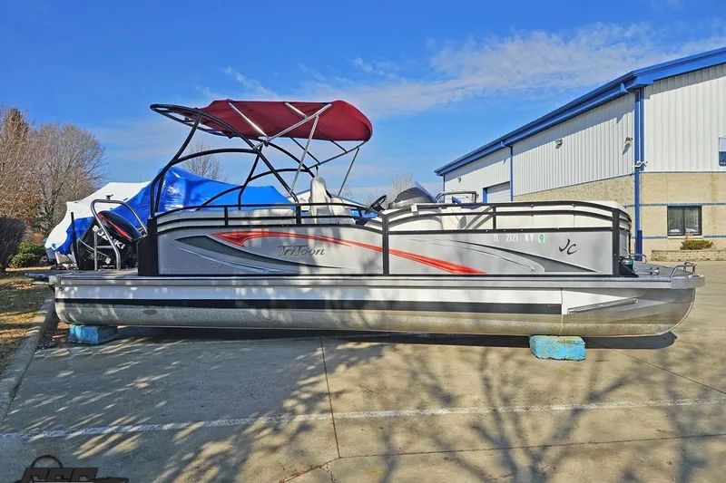 The Image of 2019 JC Tritoon Neptoon 25 Sport SL pontoon boat with red canopy, parked outdoors. - 1