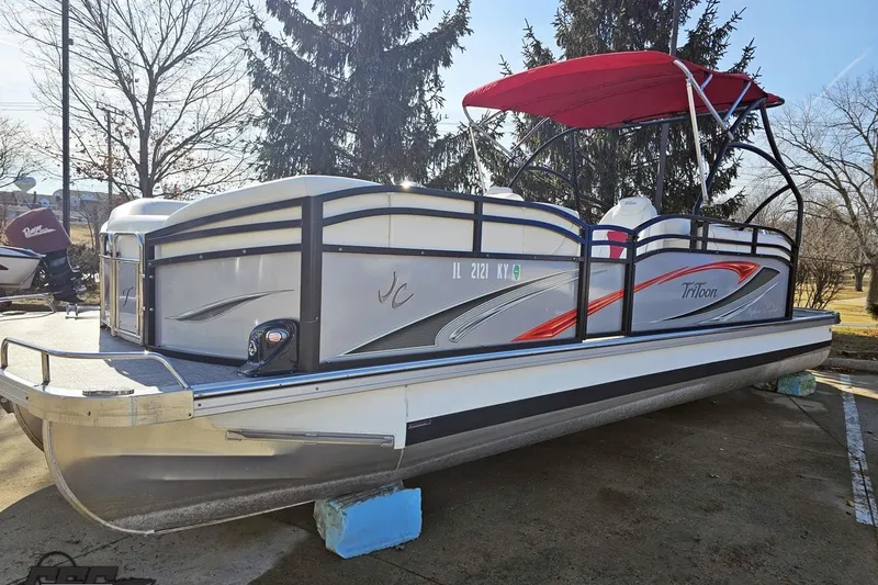 Slide: The Image of 2019 JC Tritoon Neptoon 25 Sport SL pontoon boat with red canopy, parked outdoors. - 25