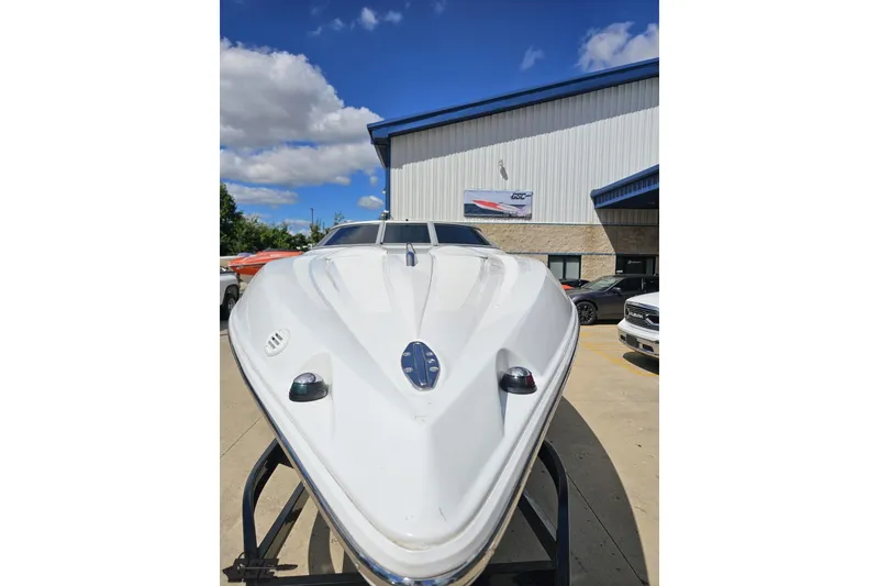 Slide: The Image of 2005 Baja 275 boat on trailer outside a building under a blue sky. - 13