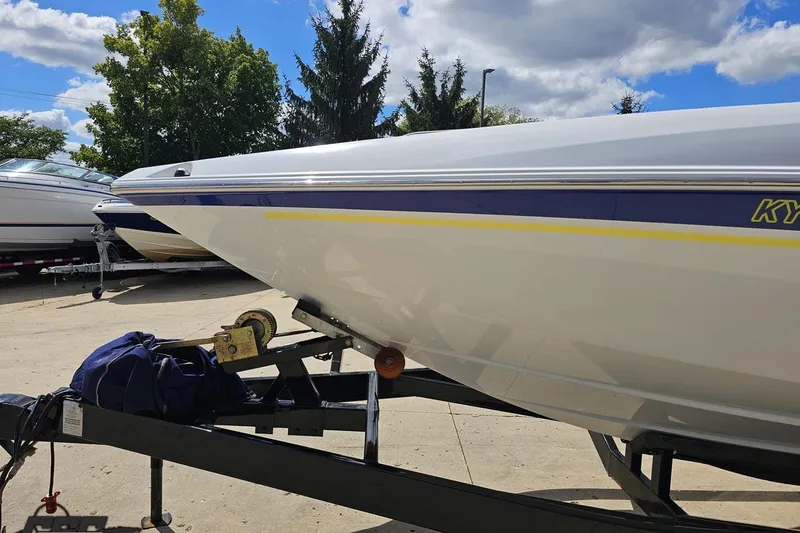 Slide: The Image of 2005 Baja 275 boat on trailer under a clear blue sky. - 14