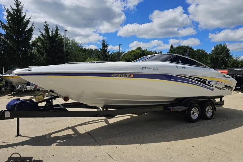 Slide: The Image of 2005 Baja 275 boat on trailer under blue sky with clouds. - 18